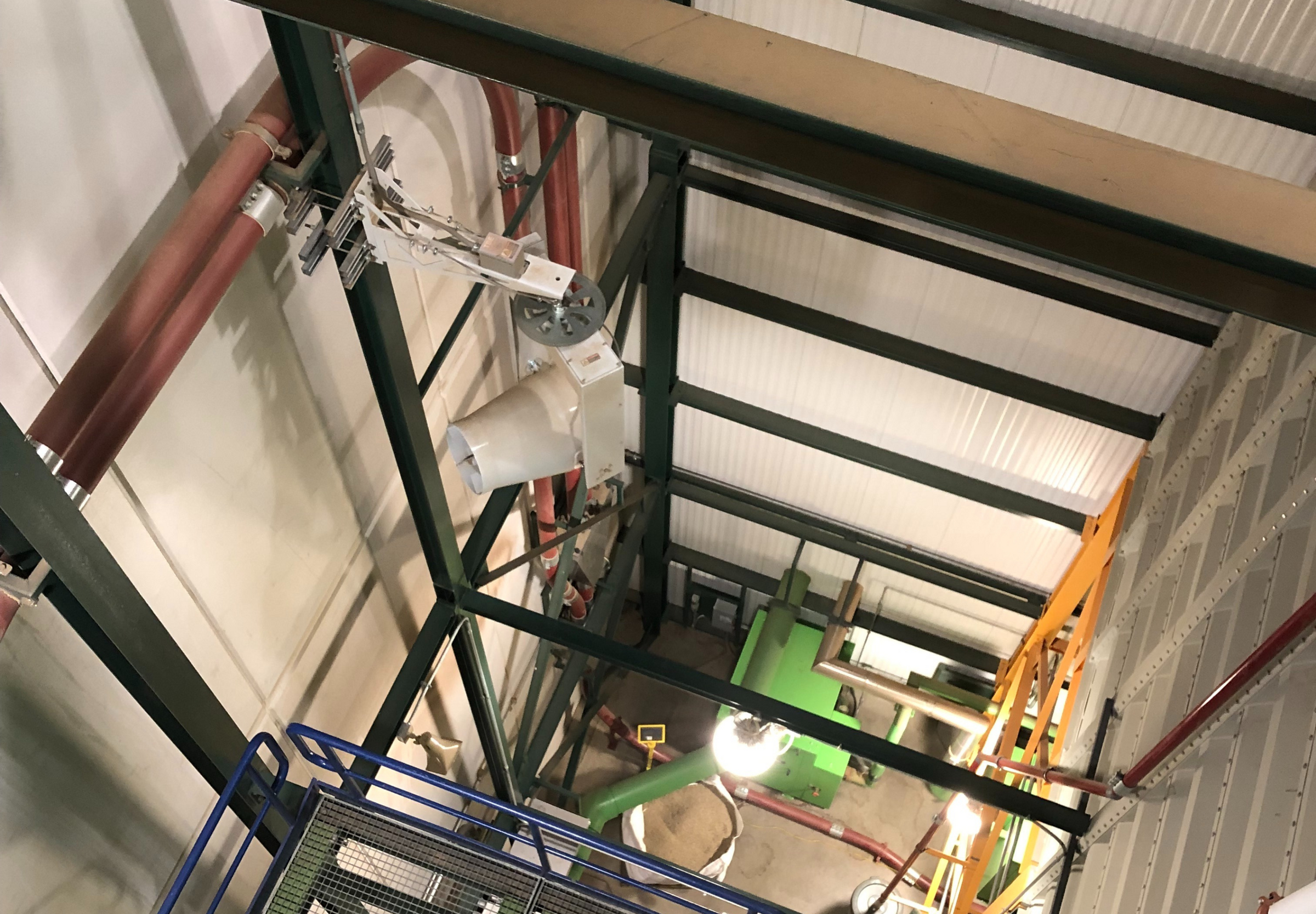 Warehouse stairwell with mounted industrial fan improving air quality and circulation.