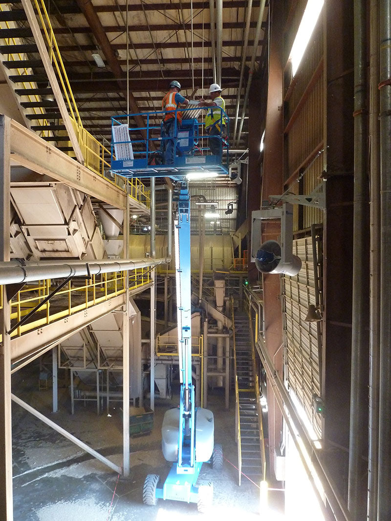 Two men on a bucket working inside warehouse