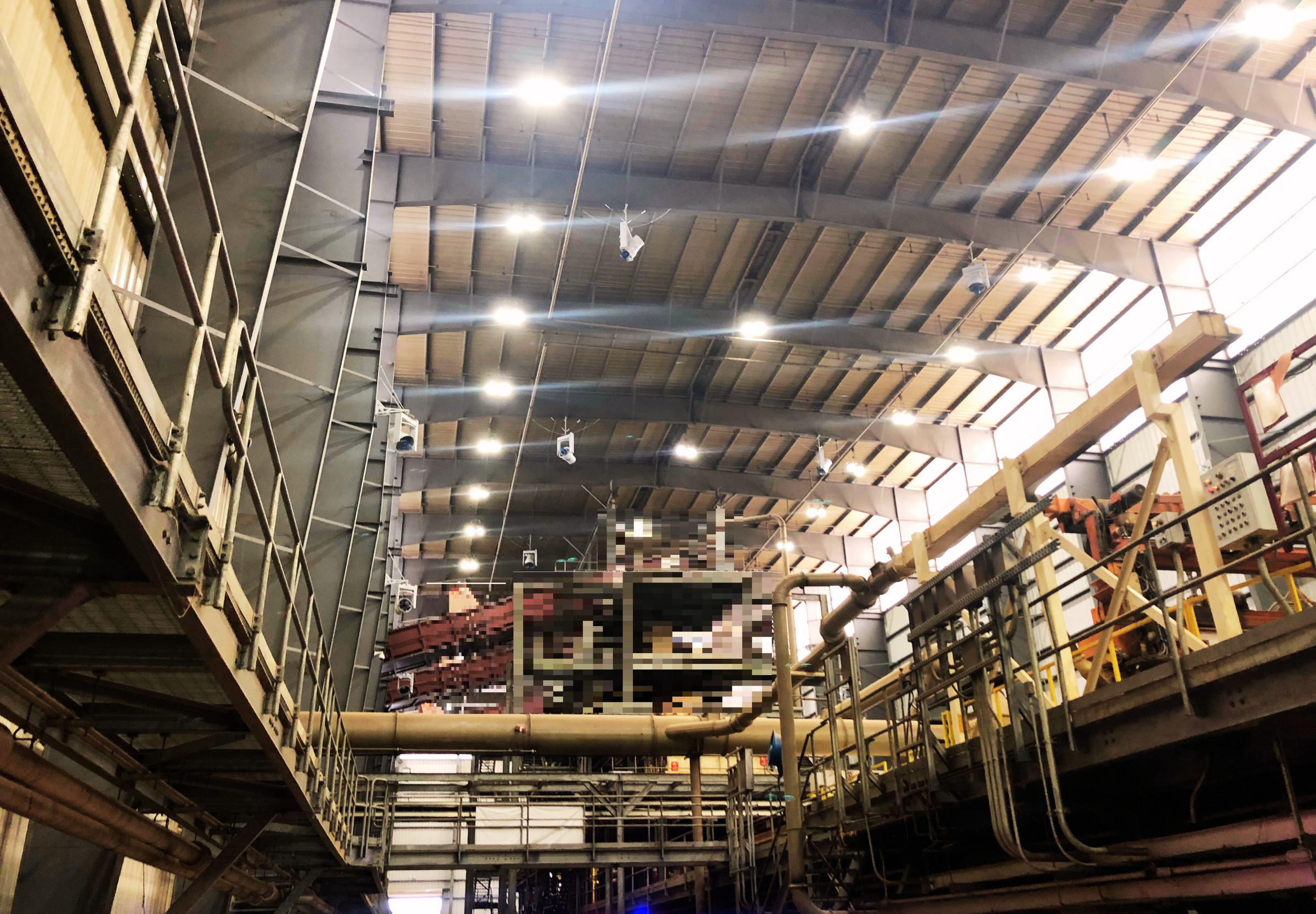  A group of high-powered industrial fan mounted on the ceiling, effectively controlling dust and debris in a warehouse setting.